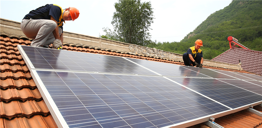 冀北公司员工为贫困户在屋顶安装太阳能光伏板