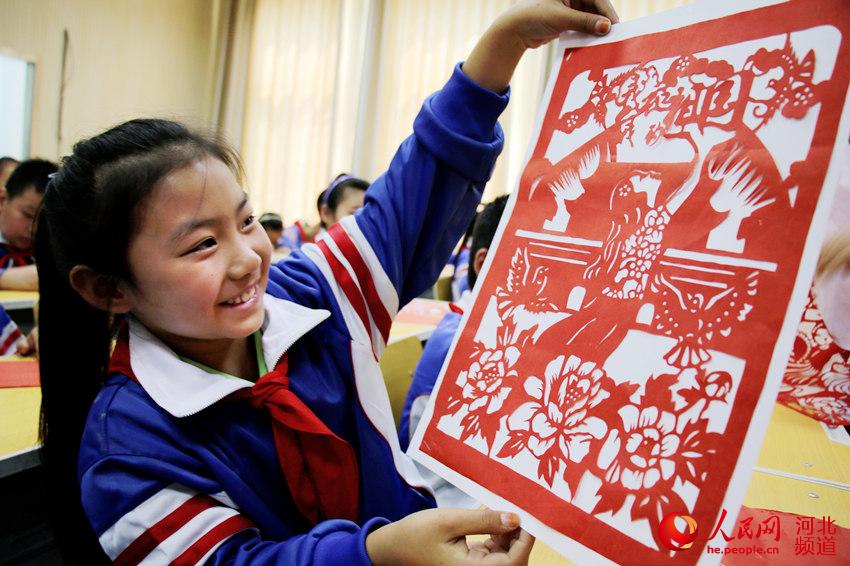 图为广平县广平小学学生展示创作的国庆剪纸作品。