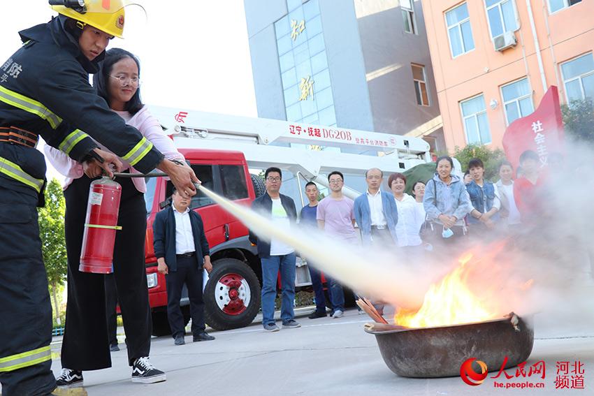 5月12日，河北省邯鄲市廣平縣消防救援大隊在該縣第二實驗小學舉行應急演練中交給老師如何正確使用滅火器。