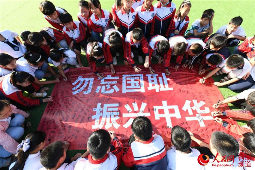 9月17日，河北省邯鄲市廣平縣濱河小學學生在“勿忘國恥 振興中華”橫幅上簽名。 程學虎、單保奇攝
