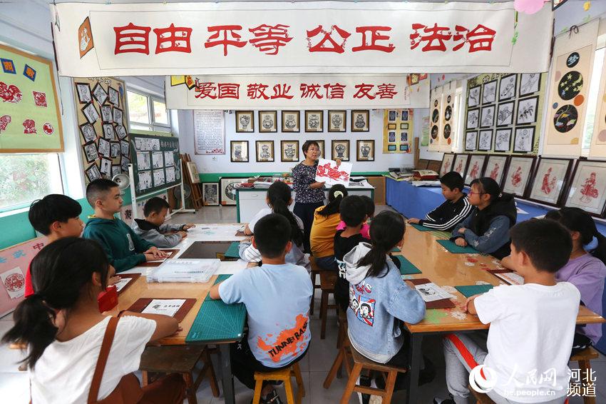 近日，河北省張家口市下花園區上花園中心小學專業剪紙教師在為孩子們上一堂生動的剪紙藝術課。 馬佳琦攝