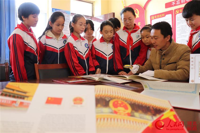 10月9日，河北省廣平縣濱河小學教師在給學生介紹郵票知識。 程學虎、單保奇攝