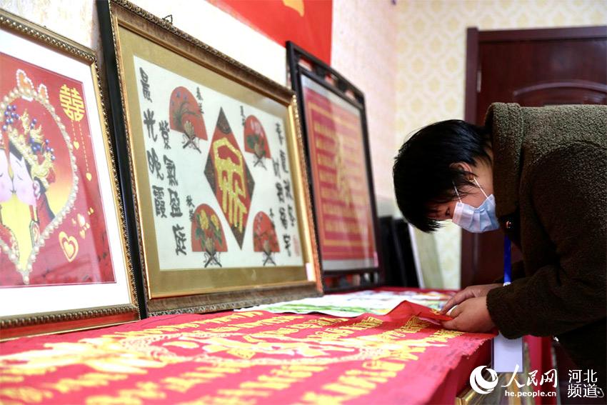 市民參觀殘疾人創作的傳統手工藝作品“十字繡”。 李國軍攝