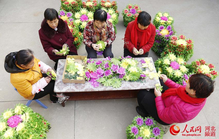 12月8日，在邢台市南和區和陽鎮三張村，婦女們在進行手工串花。張馳攝