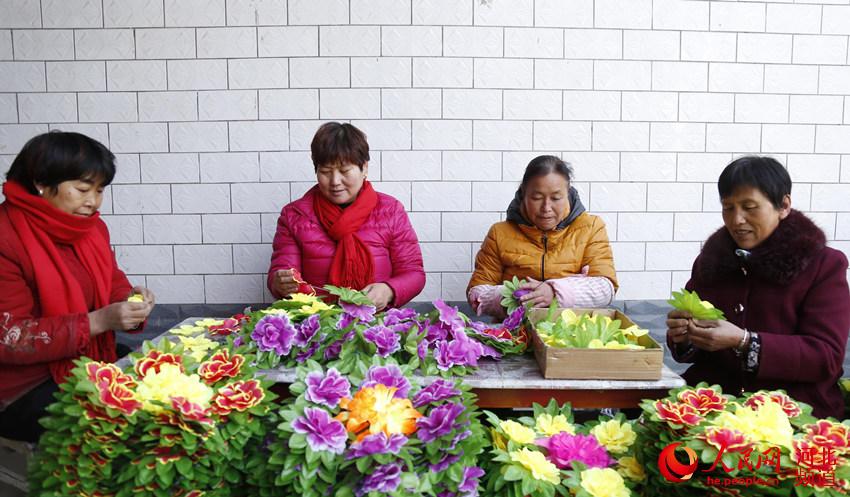 12月8日，在邢台市南和區和陽鎮三張村，婦女們在進行手工串花。張馳攝