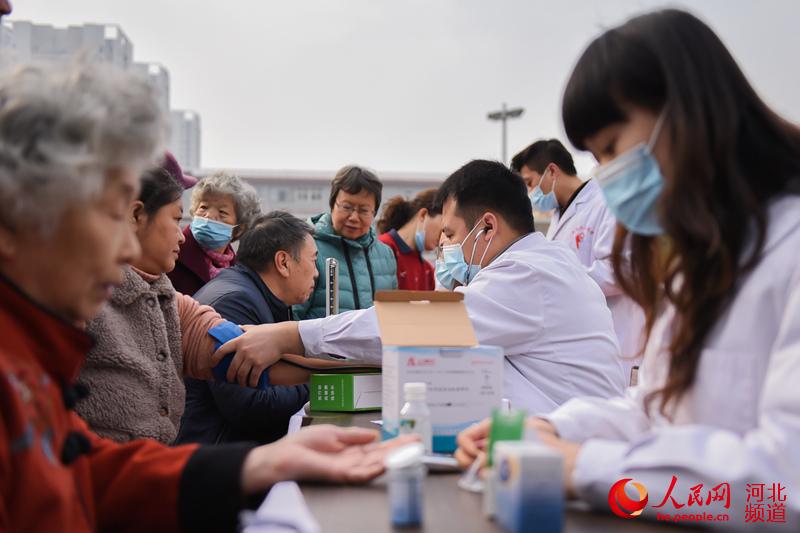 2021年3月5日，在河北省邯鄲市邯山區邯峰小區，醫生志願者為居民測量血壓。 李昊攝