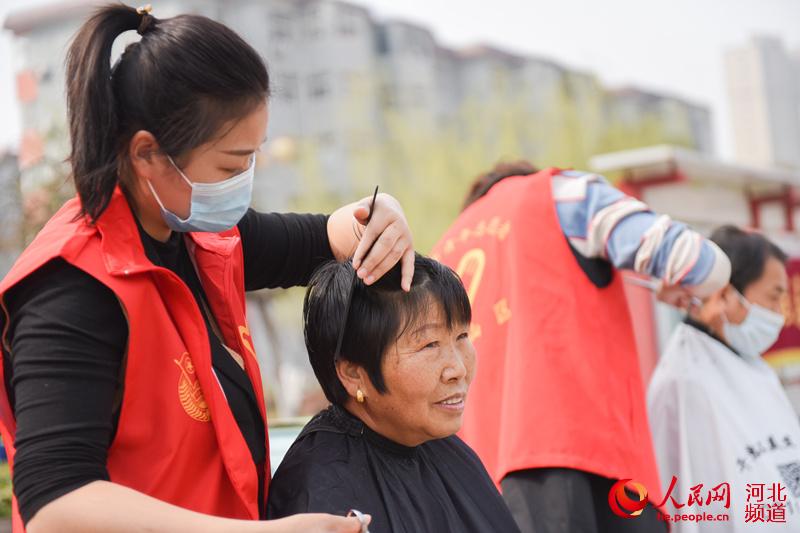 2021年3月5日，在河北省邯鄲市邯山區邯峰小區，志願者正在給居民理發。李昊攝