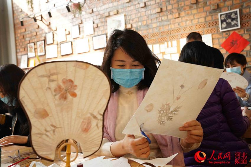 女職工在剪裁扇面，體驗團扇手工制作。 王繼軍攝