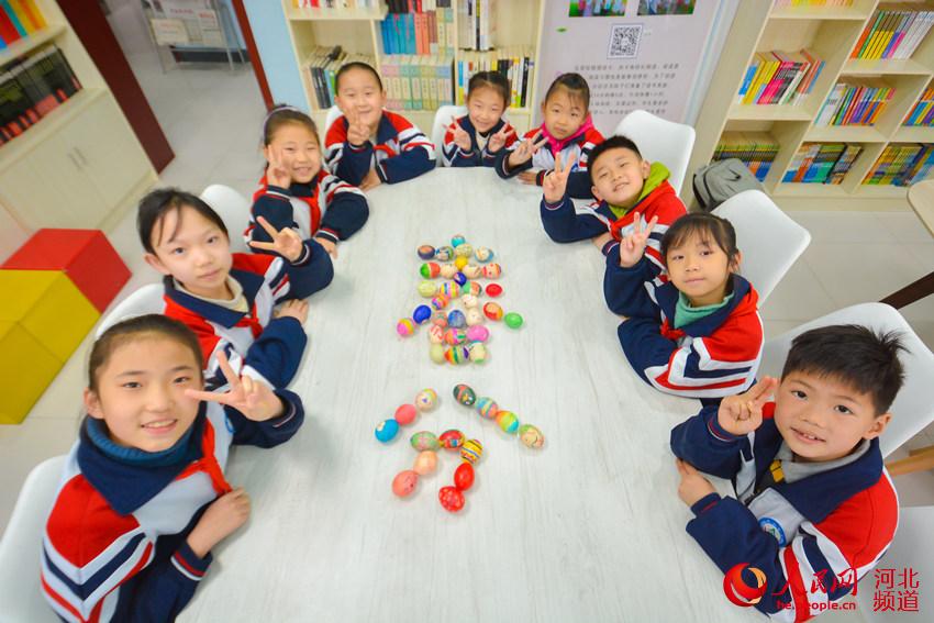 3月19日，河北邯鄲市邯山區陽光實驗小學學生用彩蛋擺成“春分”字樣。 李昊攝