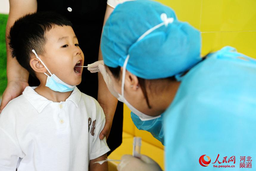 8月24日，在河北省廣平縣第四幼兒園臨時核酸檢測採樣點，醫護人員為小朋友進行核酸檢測採樣。程學虎攝