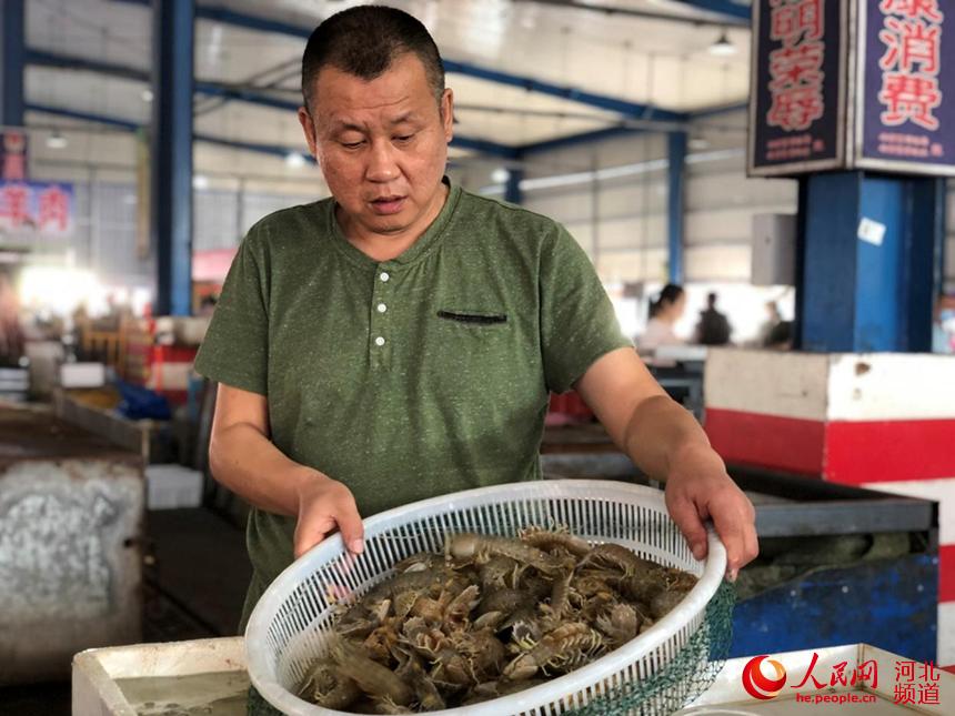海鮮商戶正在向消費者展示新鮮的皮皮蝦。 畢帥攝