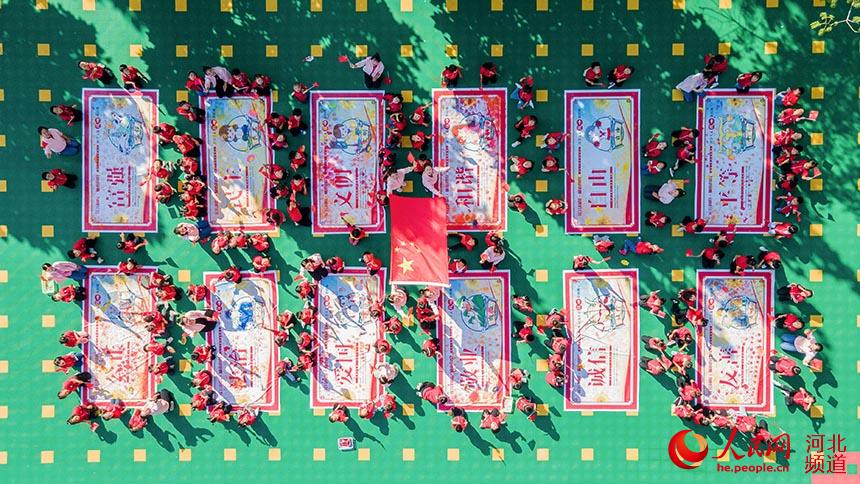 邯鄲市肥鄉區第三幼兒園的小朋友在公益宣傳畫上按手印，表達對祖國媽媽的祝福。 薛建東攝