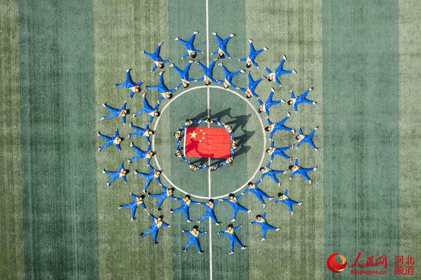 邢台市柏鄉縣南陽中心小學師生們圍繞著國旗拼成太陽的形狀。 栗建兵攝