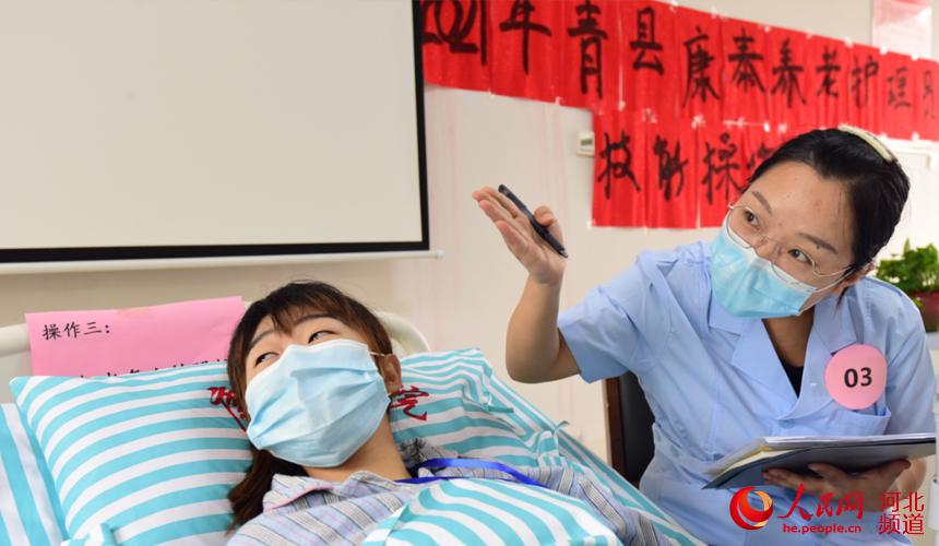 青县康泰养老护理中心养老护理员大赛比赛过程中,护理员帮助“老人”认图识字,进行“失智‘老人’照护”操作。 张鹏摄
