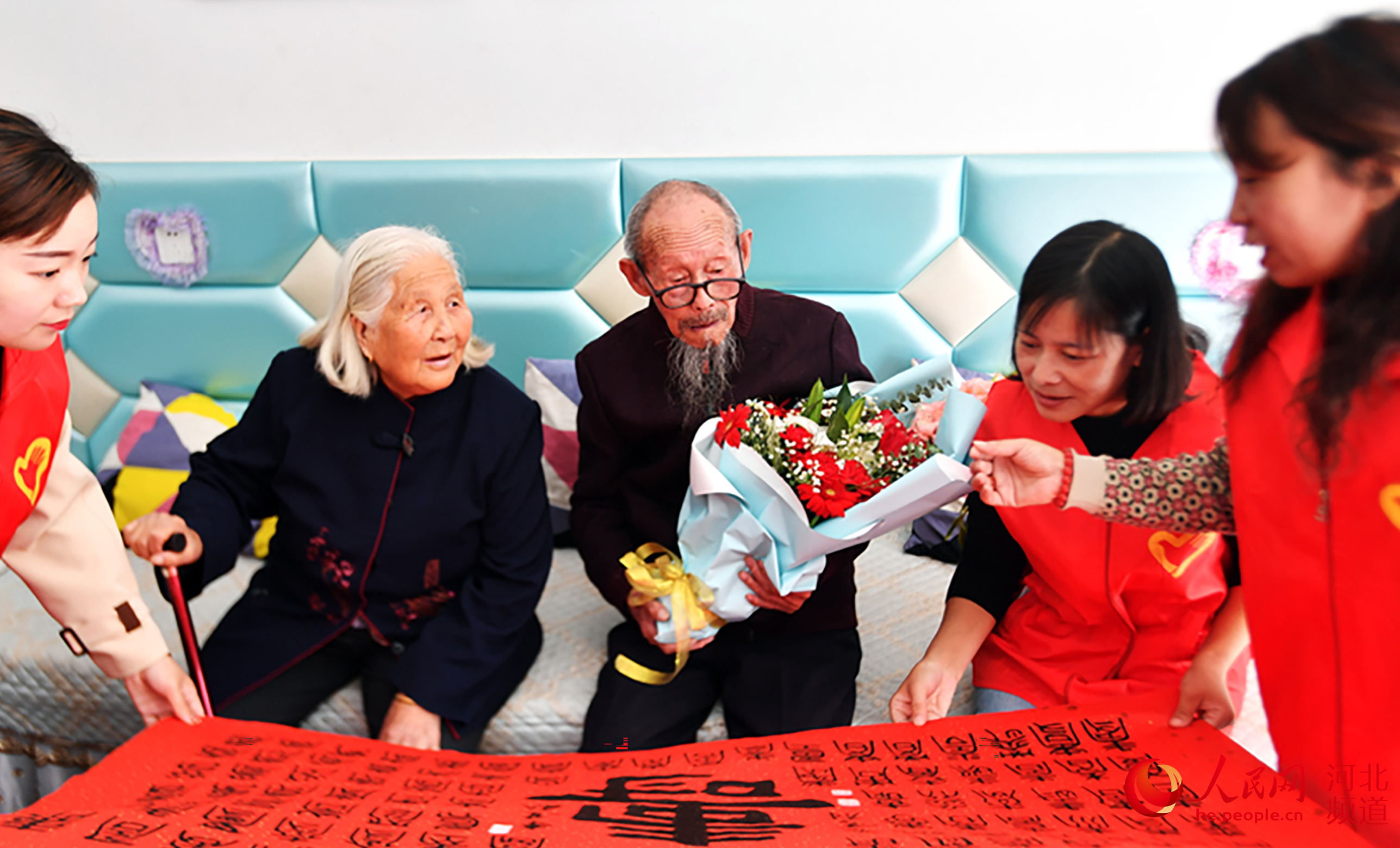 在河北迁安市滨河街道湾子社区，志愿者为101岁的张文老人讲解字画的寓意。 郭强摄