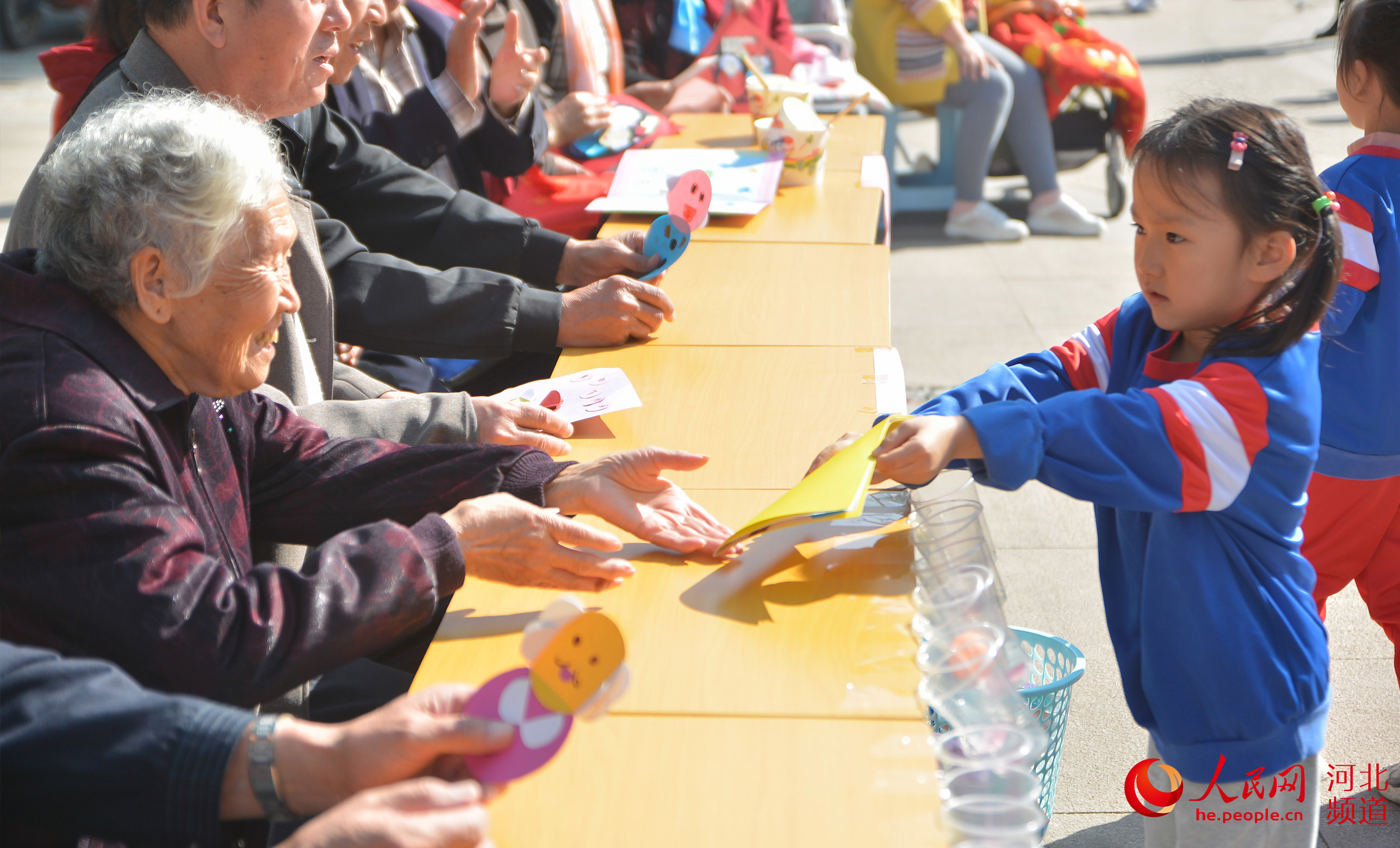 10月13日，河北邯郸市邯山区盛和路街道美和社区小朋友为老人献上节日贺卡。 李昊摄