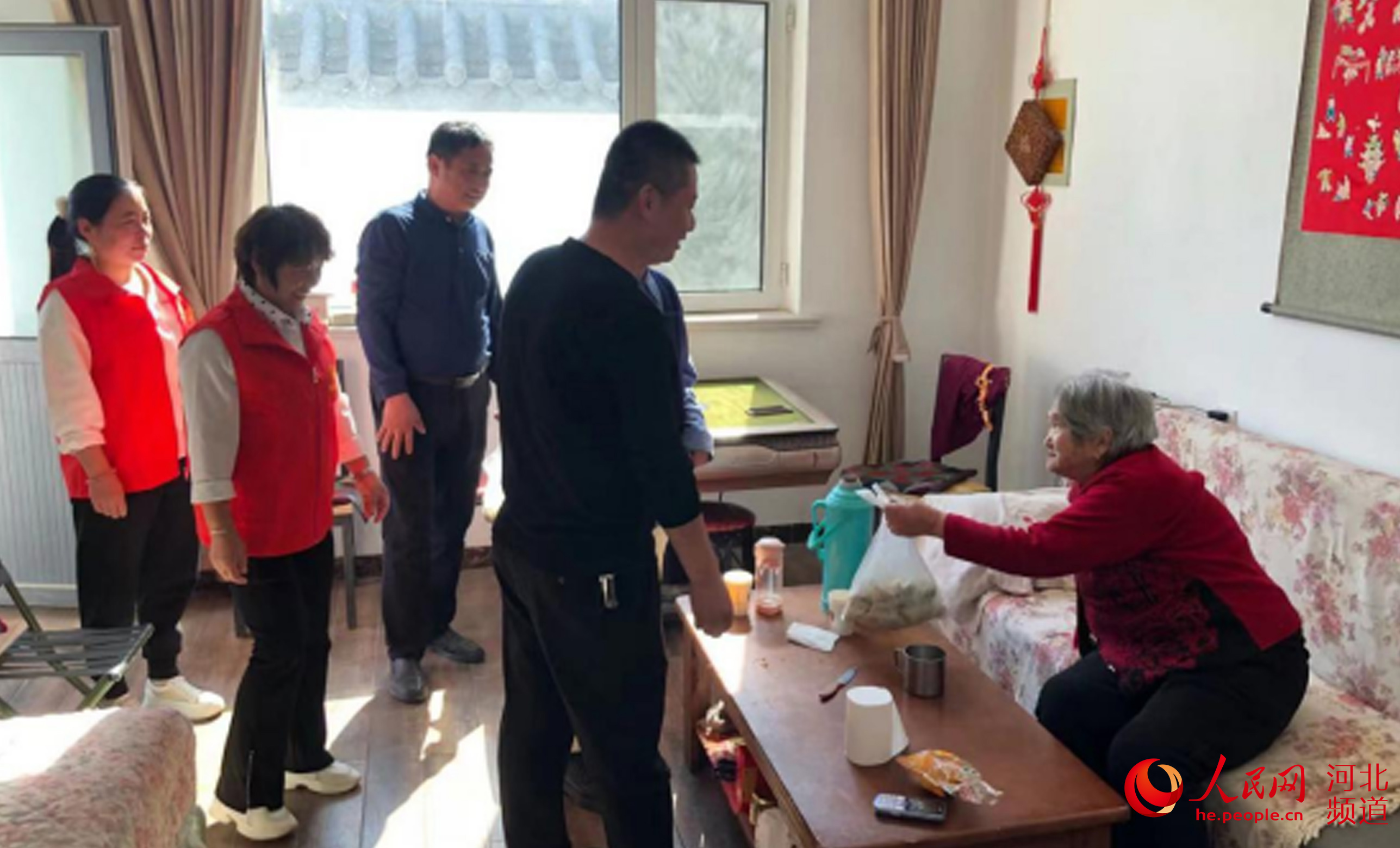 河北平乡县袁家庄村的村干部为行动不便的老人上门送饺子。李灵娟摄