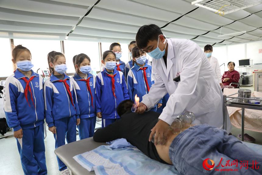 在邯郸市复兴区中医院，中医医师向复兴小学学生讲解火罐等传统中医治疗手段。王伸摄