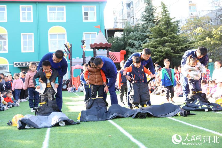 邯郸市复兴区，幼儿园小朋友穿上灭火战斗服，体验当消防员。王伸摄