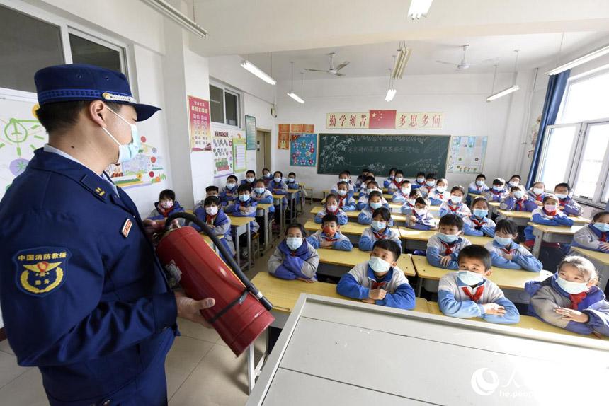 在河北文安县日上小学，文安消防救援大队消防员讲解灭火器使用注意事项。 陈有柱摄