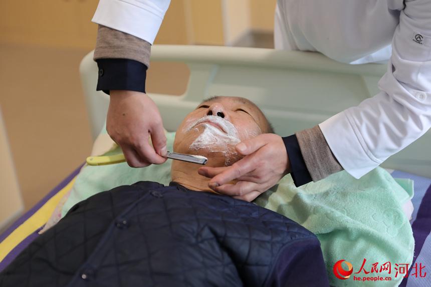 河北省邢台市巨鹿縣醫院醫養中心的醫護人員為老人剃須。 胡良川攝