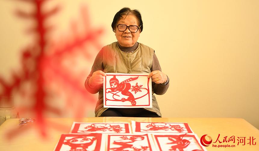 老黨員趙秀琴創作北京2022年冬奧會題材剪紙 。 劉欣羽攝