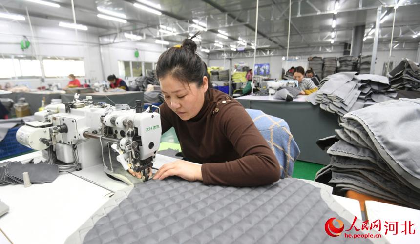 在霸州市胜芳镇一家家具企业生产车间，工人在加工餐椅外套。 刘向摄