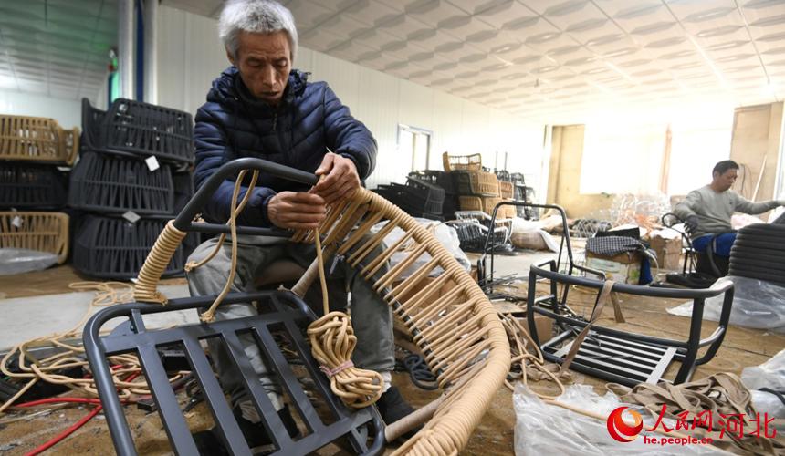 在霸州市勝芳鎮北樓村一家家具企業生產車間，工人在編織藤椅。 劉向攝