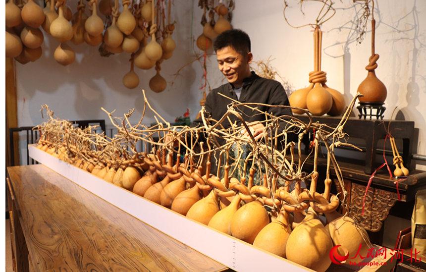 崔海东用时十年，创作《56个民族大团结》绾结葫芦工艺品。 刘亮摄