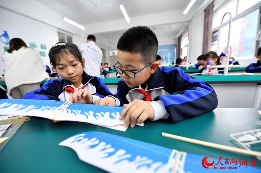 在文安县第四小学实验室，孩子们正在组装滑翔机模型。 王晖摄