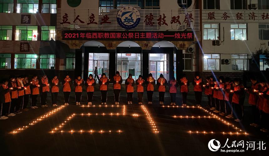 12月12日，臨西縣職教中心學生在教學樓前點亮蠟燭，同學們靜默肅立，寄托哀思，在燭光中祭奠逝者，在追思中珍愛和平。 張丹攝