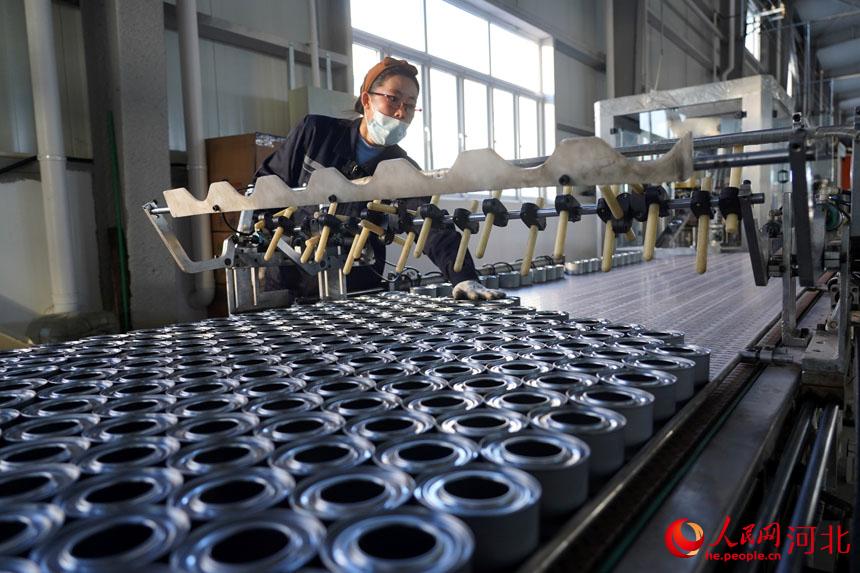 在唐山市丰南区柳树瞿阝镇一家金属包装企业的生产车间，工人正在生产加工瓶罐。 李福政摄