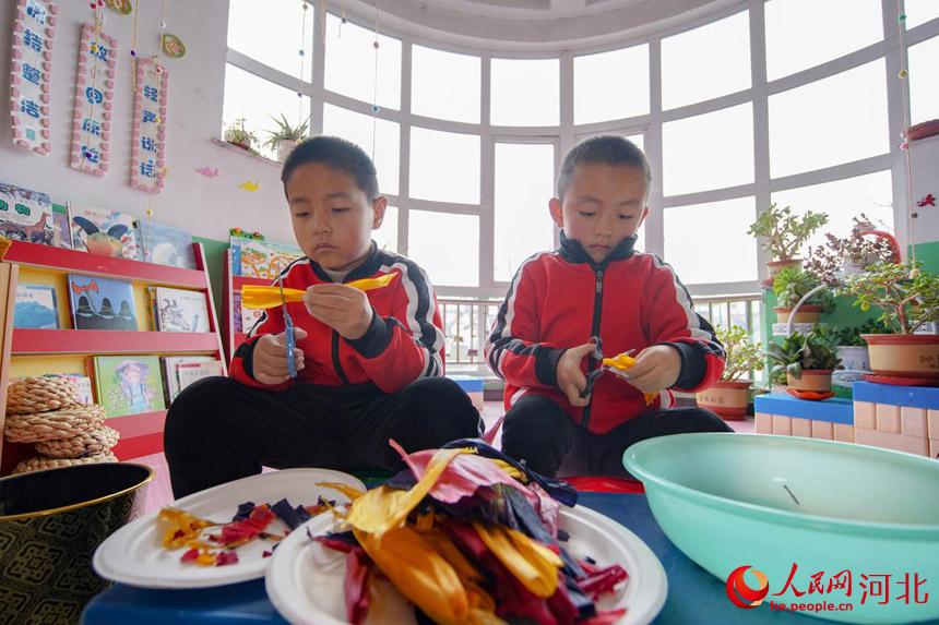 在河北省唐山市丰南区西葛镇第二幼儿园内，孩子们正在裁剪玉米皮用于编织。李福政摄