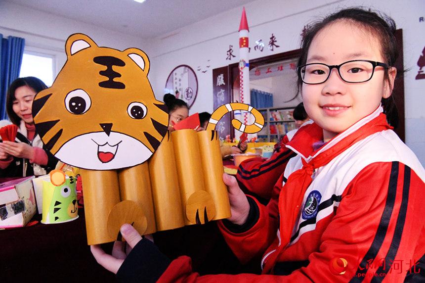 河北省邯郸市广平县滨河小学学生在展示制作的生肖虎手工。 程学虎摄