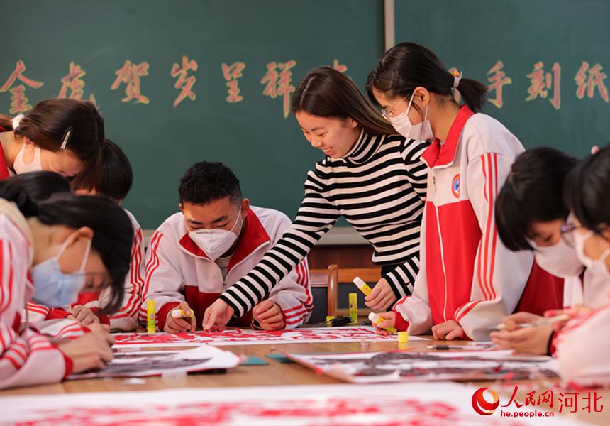 河北省邢台市廣宗縣葫蘆中學，美術老師和學生在一起進行刻紙作品創作。 王壘攝
