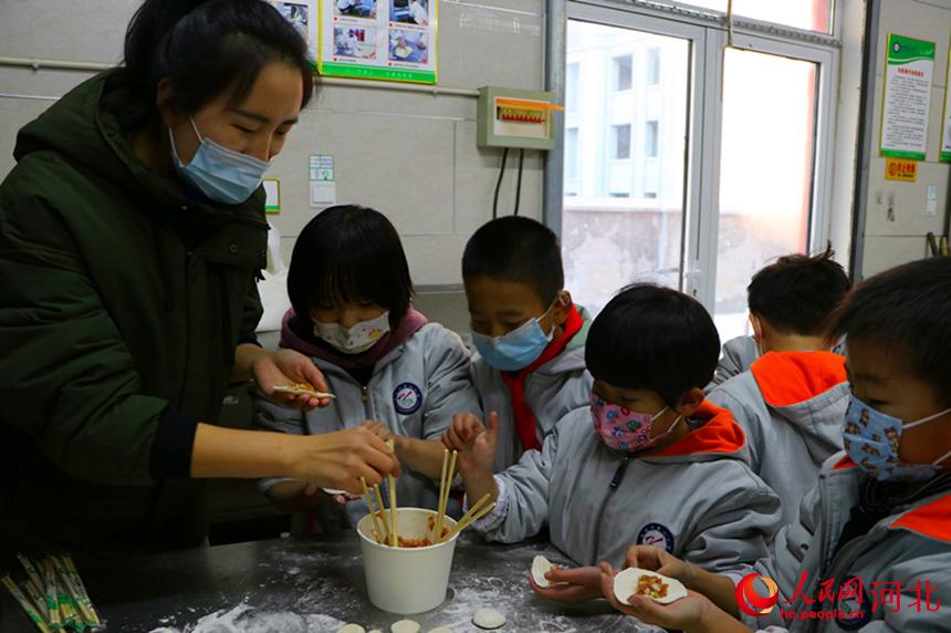 河北省南宮市第二小學以傳統的“包餃子”方式和留守兒童一起喜迎新年。 王林攝