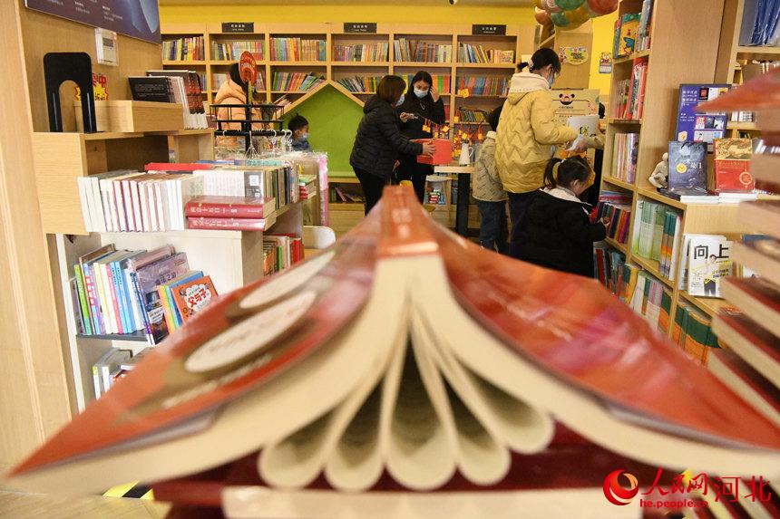 邯鄲市廣平縣市民帶著孩子在書店挑選圖書。 程學虎攝