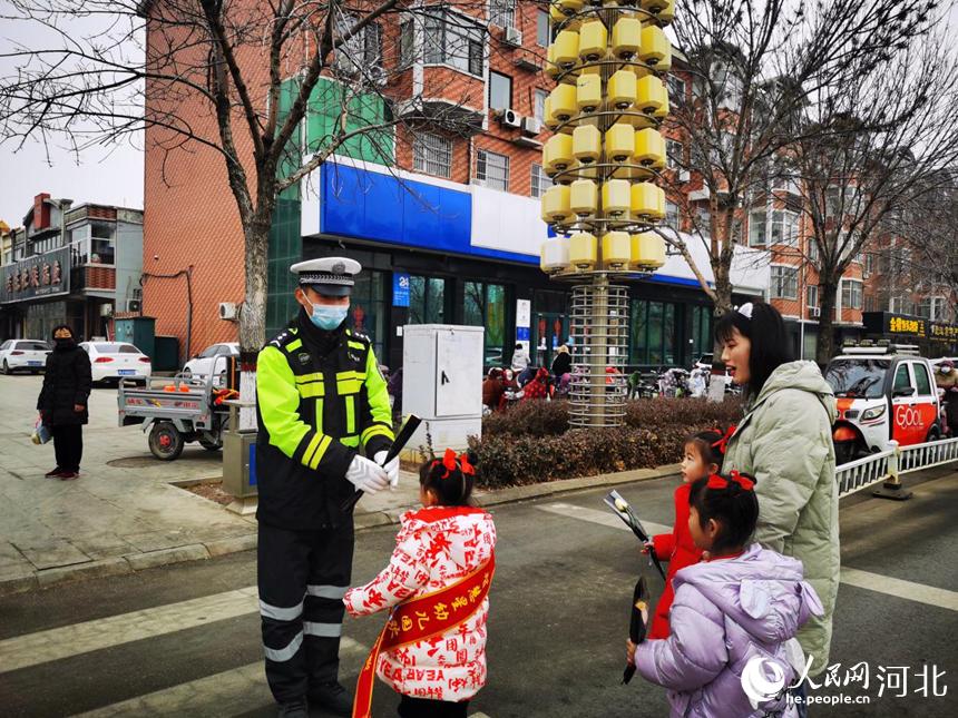 河北省滄州市東光縣幼兒園的小朋友為路口執勤的交警獻上鮮花。 馮麗麗攝