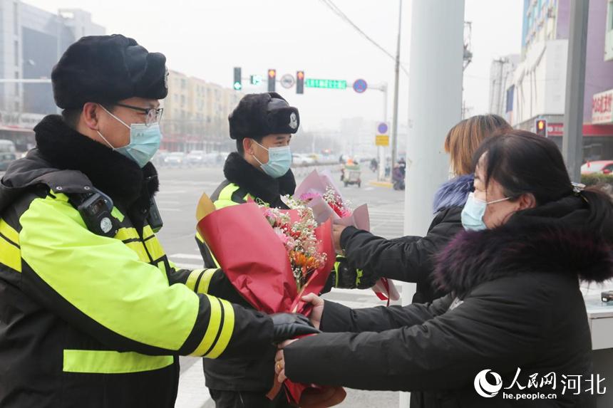在滄州市解放東路欣怡小區路口，兩名結伴而來的女子手捧著鮮花送到了滄州市公安交警二大隊執勤交警的手中，送來了“警察節”的問候和祝福。 桂茂亭攝