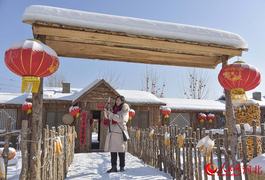 游客在遵化市山裡各庄村雪鄉風情街直播打卡。 張旭攝