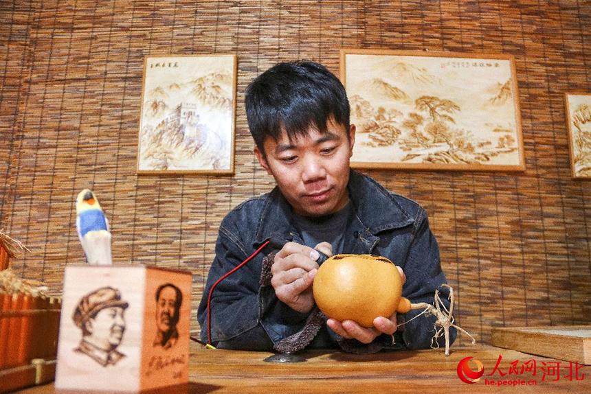 2022年1月20日，河北省青县非遗葫芦烙画第四代传承人以电烙铁为笔，在葫芦上进行“迎冬奥”主题创作。 尹向平摄