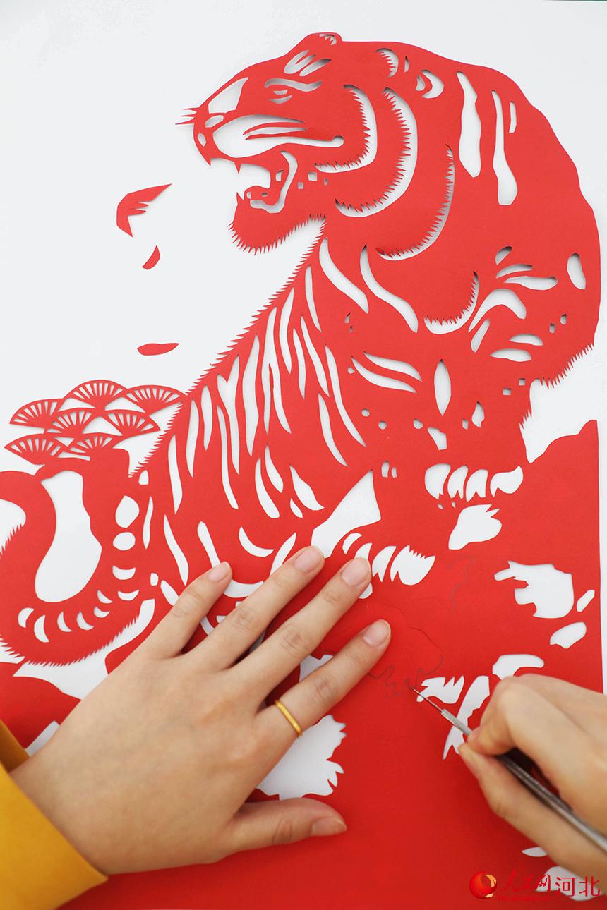 河北省唐山市豐潤區太平路街道同安社區居民在創作虎主題剪紙作品。 朱大勇攝