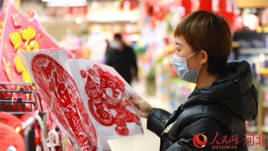 喜慶的窗花吸引了大家駐足挑選。劉鵬攝