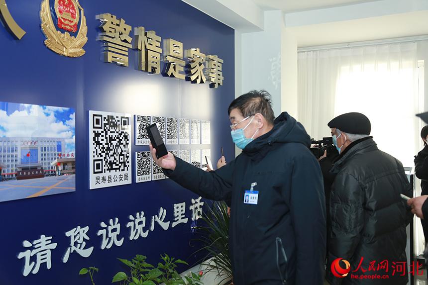 扫码评警监督员在体验扫码评警流程。 灵寿县公安局供图