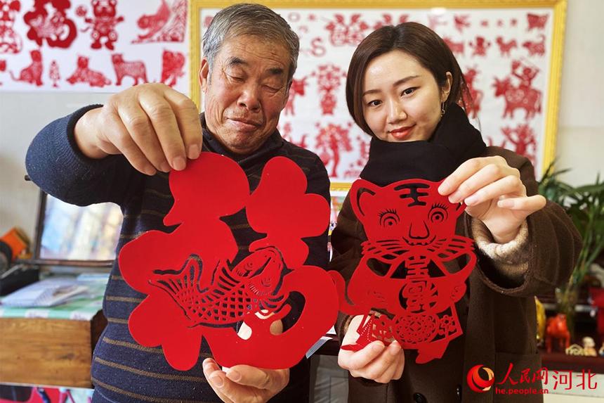 1月27日，72歲的剪紙藝術愛好者姚家貴老人，正在向我們展示剪紙作品。 張美娜攝