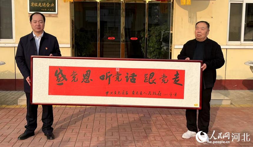 東光縣人大常委會主任劉福生為企業送去匾額。 曲媛媛攝