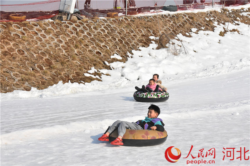 小朋友坐在滑雪圈上愉快滑雪。 李揚攝