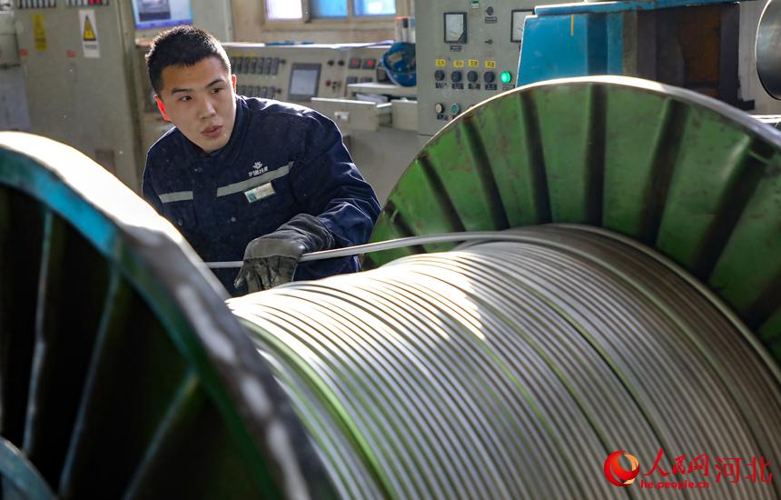 河北省唐山市豐南區一家電纜制造企業的生產車間內，工人正在生產線上趕制生產訂單。 李福政攝