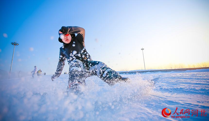 在河北省滦州市的一家滑雪场，孩子在寒假期间体验单板滑雪。 李阳摄