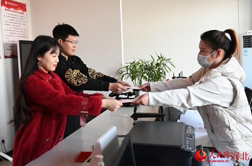 2022年2月22日，在河北省邯鄲市館陶縣民政局婚姻登記處，一對新人在工作人員手中接過結婚証。 胡清華攝